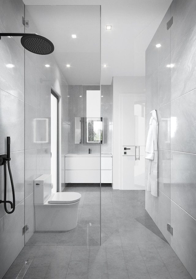 bathroom featuring toilet, a walk in shower, tile walls, and vanity