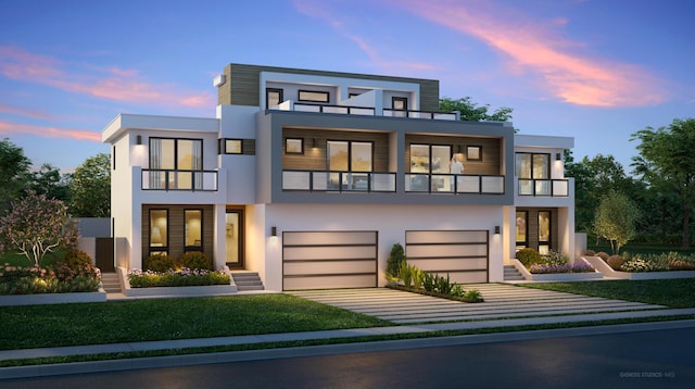 view of front of house with a garage, driveway, a balcony, and stucco siding