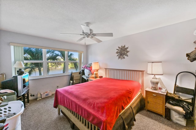 carpeted bedroom featuring a textured ceiling and a ceiling fan