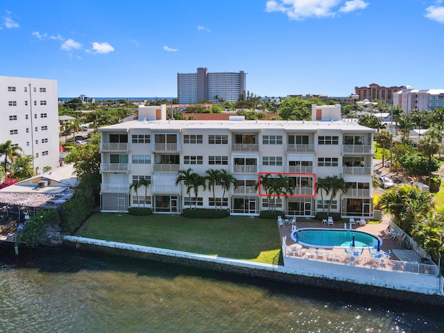 view of building exterior featuring a water view and a community pool