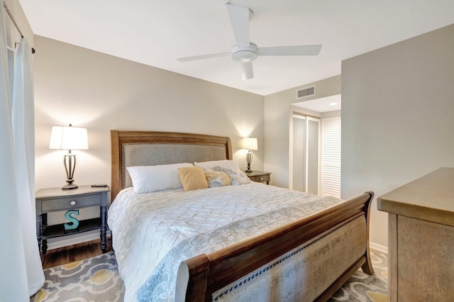 bedroom featuring visible vents, a closet, wood finished floors, and a ceiling fan