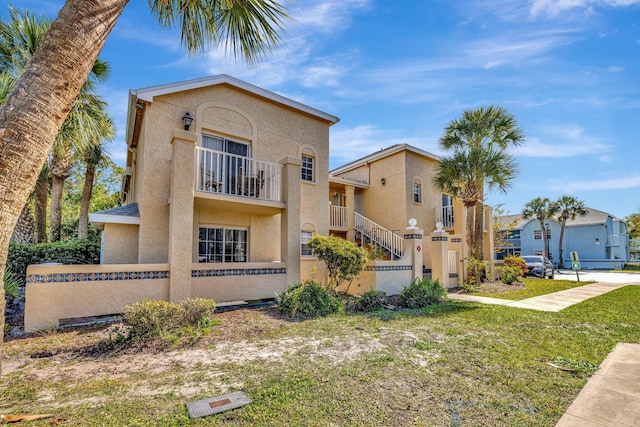 mediterranean / spanish-style home featuring stucco siding, a balcony, and fence