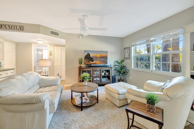 living area featuring visible vents and ceiling fan