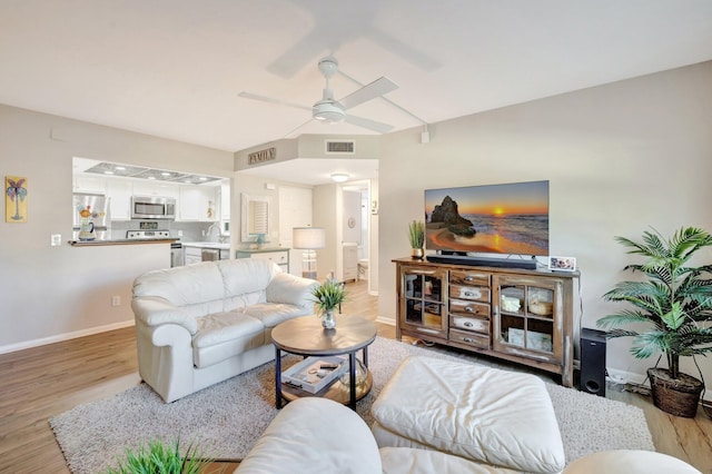 living area with baseboards, visible vents, light wood finished floors, and ceiling fan