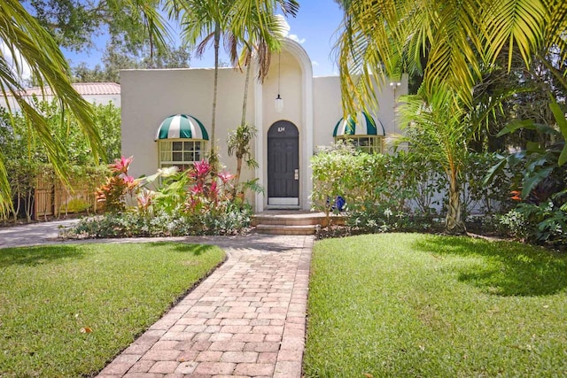 mediterranean / spanish-style house with a front lawn and stucco siding