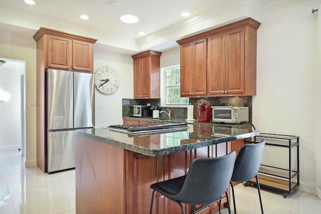 kitchen featuring a toaster, appliances with stainless steel finishes, crown molding, a kitchen breakfast bar, and tasteful backsplash