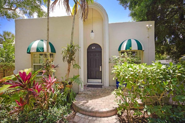 view of exterior entry with stucco siding