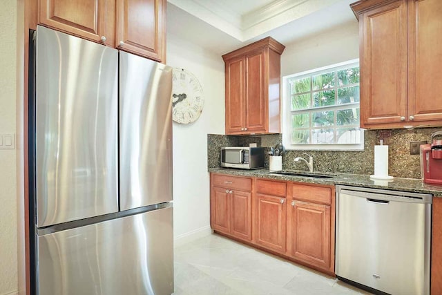 kitchen featuring a sink, dark stone counters, tasteful backsplash, and stainless steel appliances