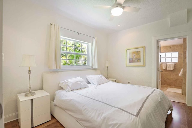 bedroom featuring connected bathroom, a textured ceiling, a ceiling fan, and wood finished floors