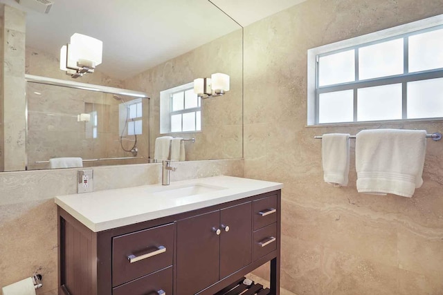 full bath featuring vanity, a shower stall, tile walls, and visible vents