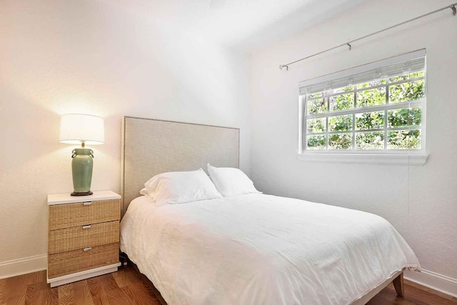 bedroom with baseboards and wood finished floors