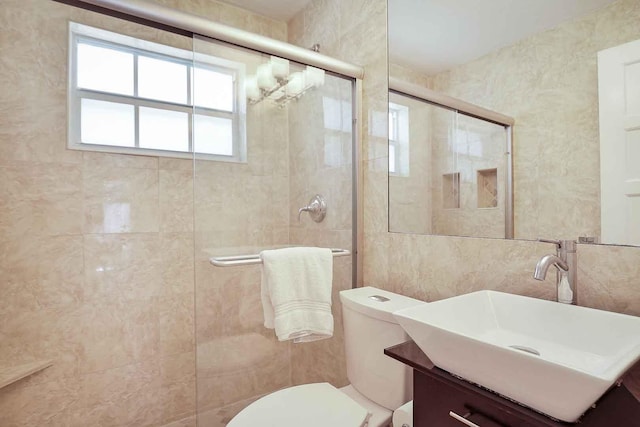 full bath featuring toilet, tile walls, vanity, and a tile shower