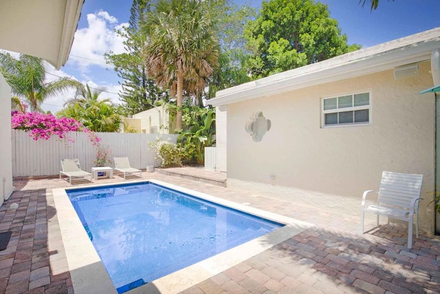 view of swimming pool with a patio area and fence