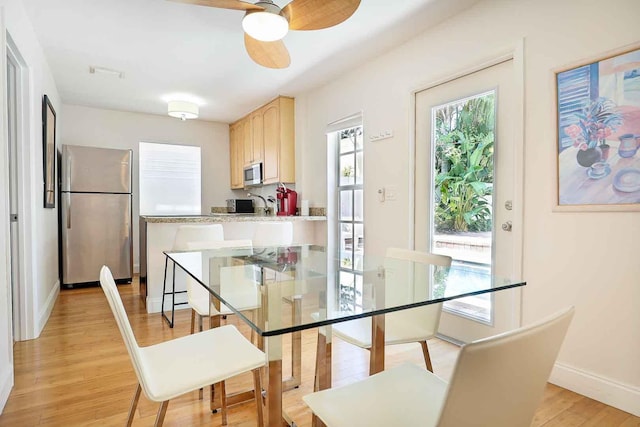 dining area with visible vents, baseboards, light wood-type flooring, and ceiling fan