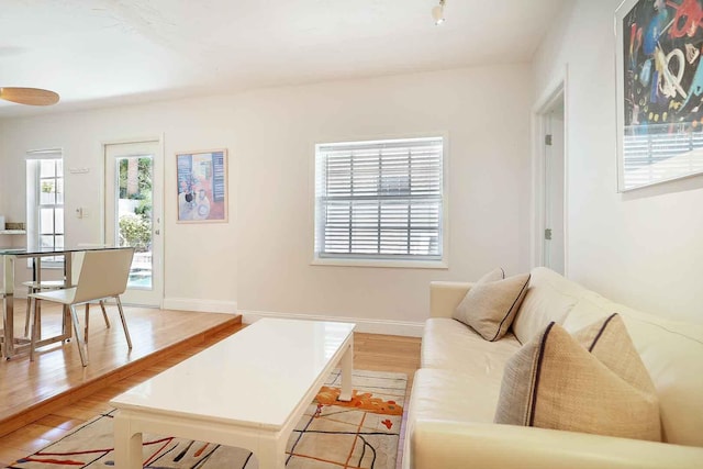 living area with baseboards and light wood finished floors