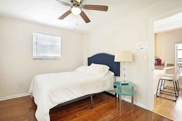 bedroom with ceiling fan, baseboards, and wood finished floors