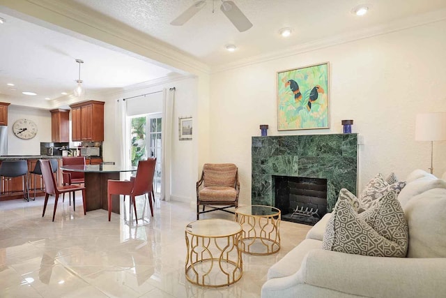 living room featuring recessed lighting, crown molding, a premium fireplace, baseboards, and ceiling fan