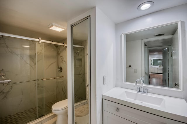 full bath featuring a marble finish shower, visible vents, vanity, and toilet