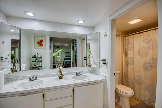 bathroom featuring a sink, toilet, and double vanity