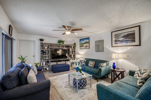 living room with ceiling fan, a textured ceiling, and wood finished floors