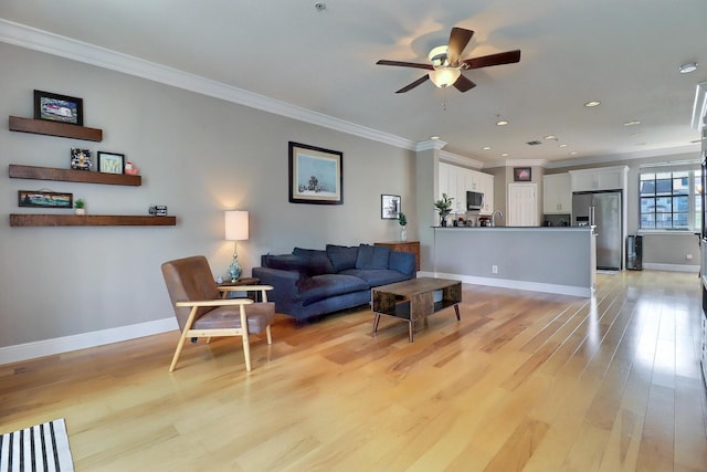 living area featuring light wood-type flooring, baseboards, and ornamental molding