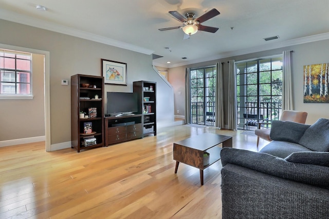 living room featuring ceiling fan, wood finished floors, visible vents, baseboards, and crown molding