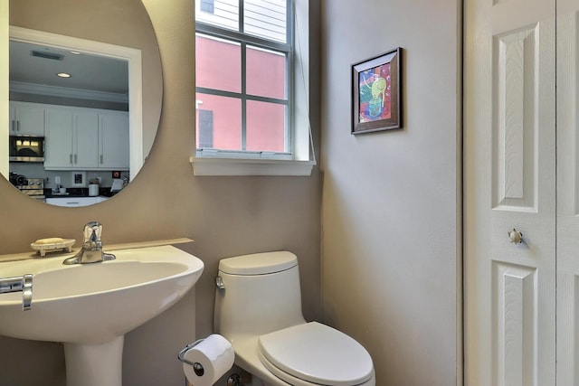 bathroom with a healthy amount of sunlight, a sink, visible vents, and toilet