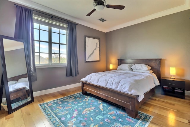 bedroom with visible vents, ceiling fan, baseboards, and wood finished floors