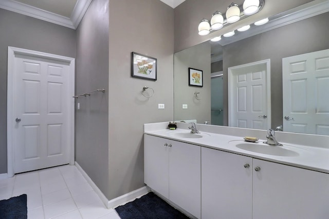 bathroom featuring crown molding, tile patterned flooring, a sink, and baseboards