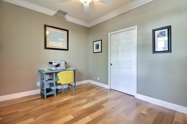 office space with ceiling fan, visible vents, baseboards, light wood-style floors, and crown molding