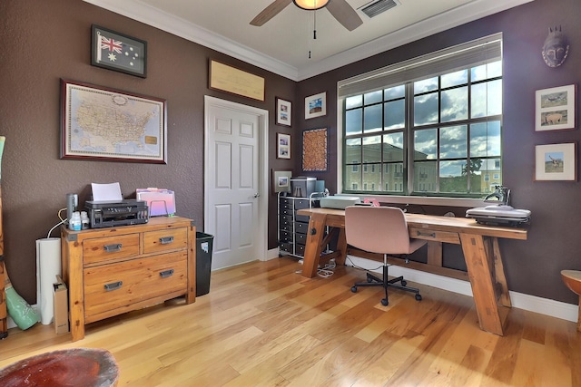 office space featuring light wood finished floors, baseboards, visible vents, and crown molding