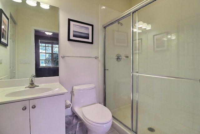 bathroom with toilet, a shower stall, and vanity