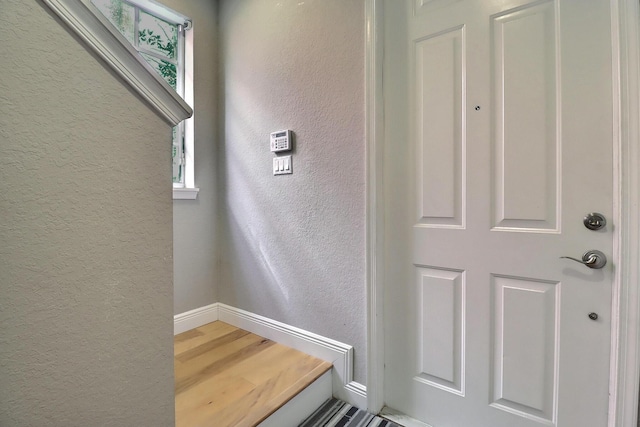 interior space with a textured wall and baseboards