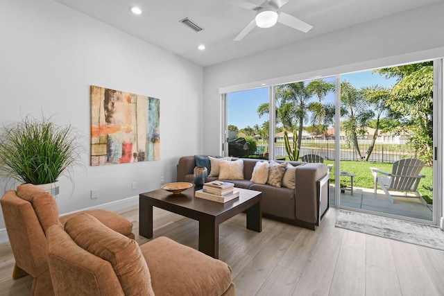 living room featuring visible vents, baseboards, ceiling fan, light wood-type flooring, and recessed lighting