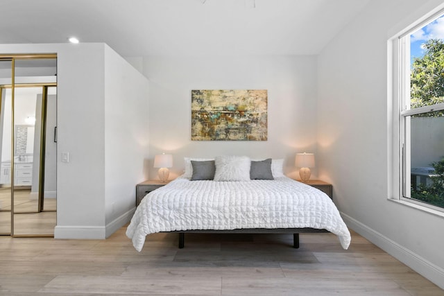 bedroom featuring wood finished floors and baseboards