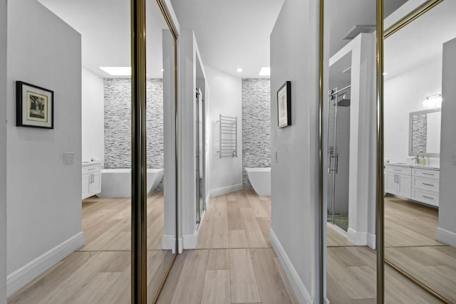 corridor with recessed lighting, baseboards, and light wood-style flooring