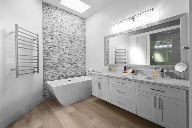 bathroom with wood finished floors, radiator heating unit, a skylight, a shower stall, and double vanity