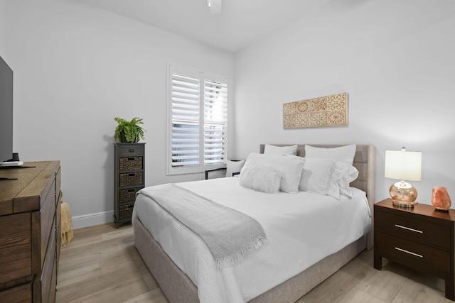 bedroom featuring light wood-type flooring, baseboards, and ceiling fan