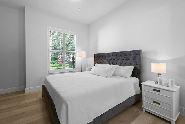 bedroom featuring baseboards and wood finished floors