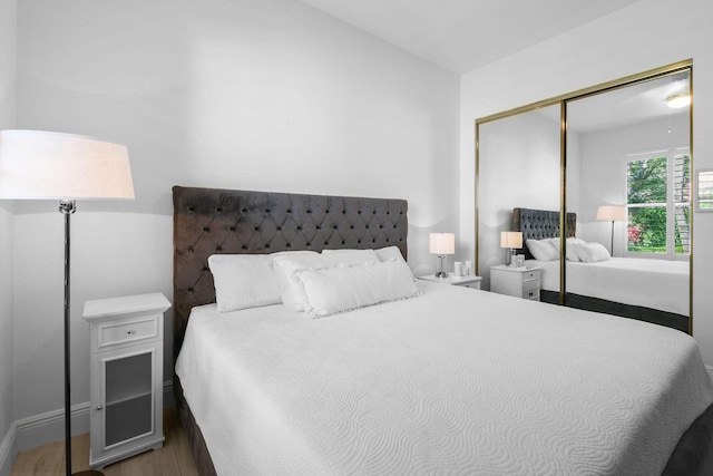 bedroom with a closet, lofted ceiling, and wood finished floors