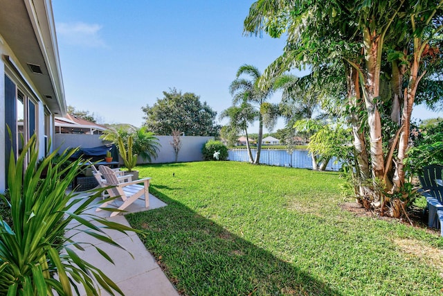 view of yard featuring a water view, a patio, and fence private yard