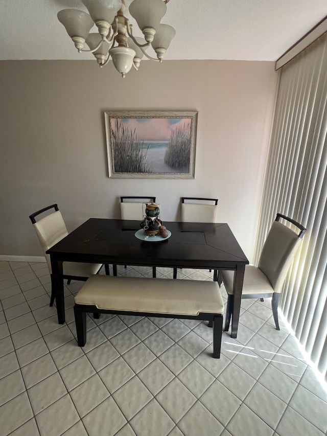 dining area featuring light tile patterned floors and an inviting chandelier