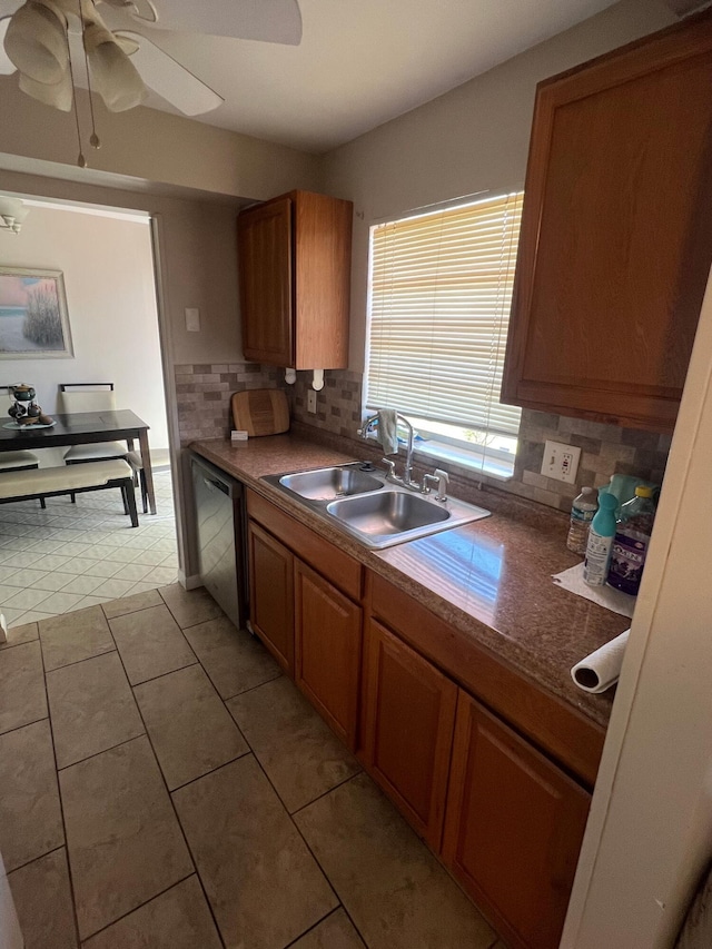 kitchen with brown cabinetry, dishwasher, a sink, and tasteful backsplash