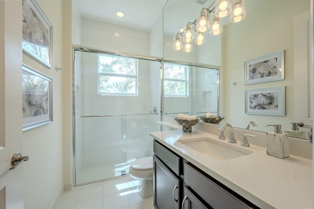 full bath featuring toilet, a stall shower, vanity, baseboards, and tile patterned floors