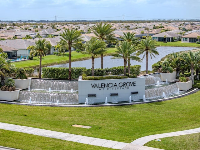 community / neighborhood sign with a yard, a water view, and a residential view