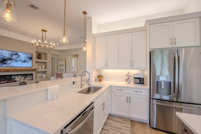 kitchen with light countertops, visible vents, appliances with stainless steel finishes, white cabinets, and a sink