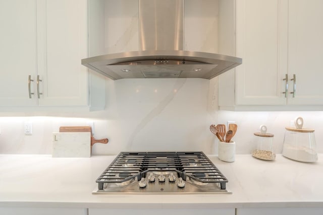 details with light countertops, ventilation hood, white cabinets, and stainless steel gas stovetop