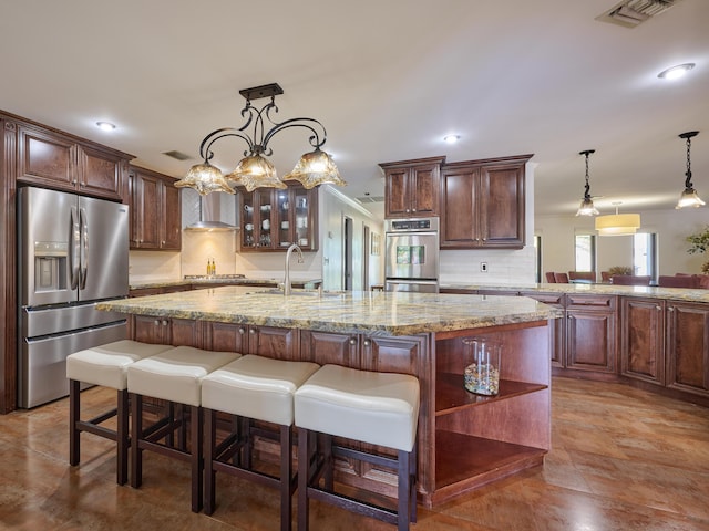 kitchen with a center island with sink, open shelves, visible vents, appliances with stainless steel finishes, and a sink