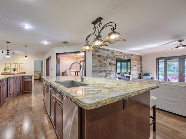 kitchen with crown molding, visible vents, open floor plan, and a sink