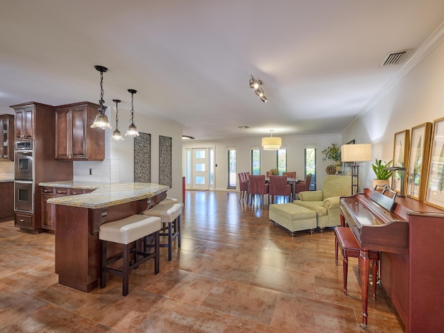 kitchen with a breakfast bar, visible vents, backsplash, glass insert cabinets, and open floor plan